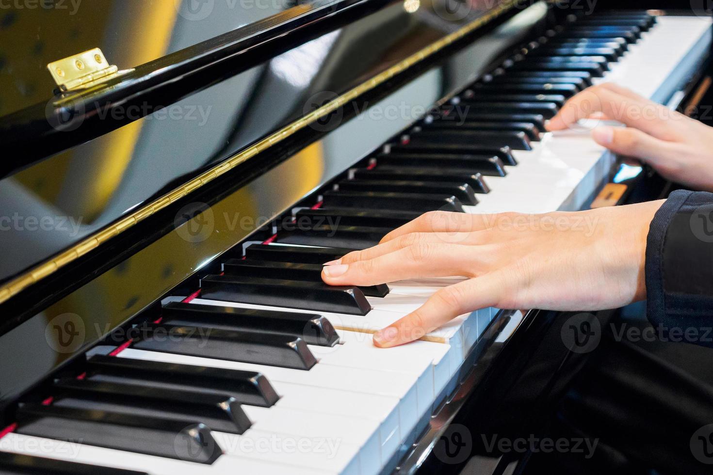 chiuda sulla mano del musicista che suona il pianoforte foto