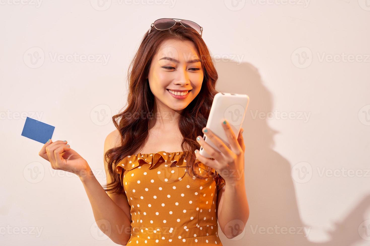 bellissimo asiatico eleganza femmina godere in linea shopping con credito carta e smartphone attività commerciale idee concetto foto