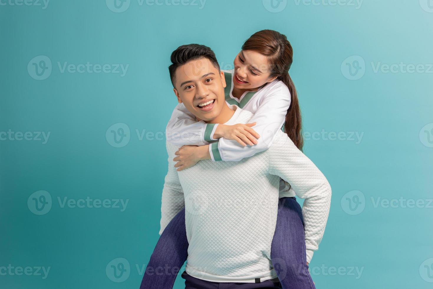 la spesa grande tempo insieme. contento giovane uomo trasporto il suo bellissimo fidanzata su le spalle e sorridente mentre in piedi foto