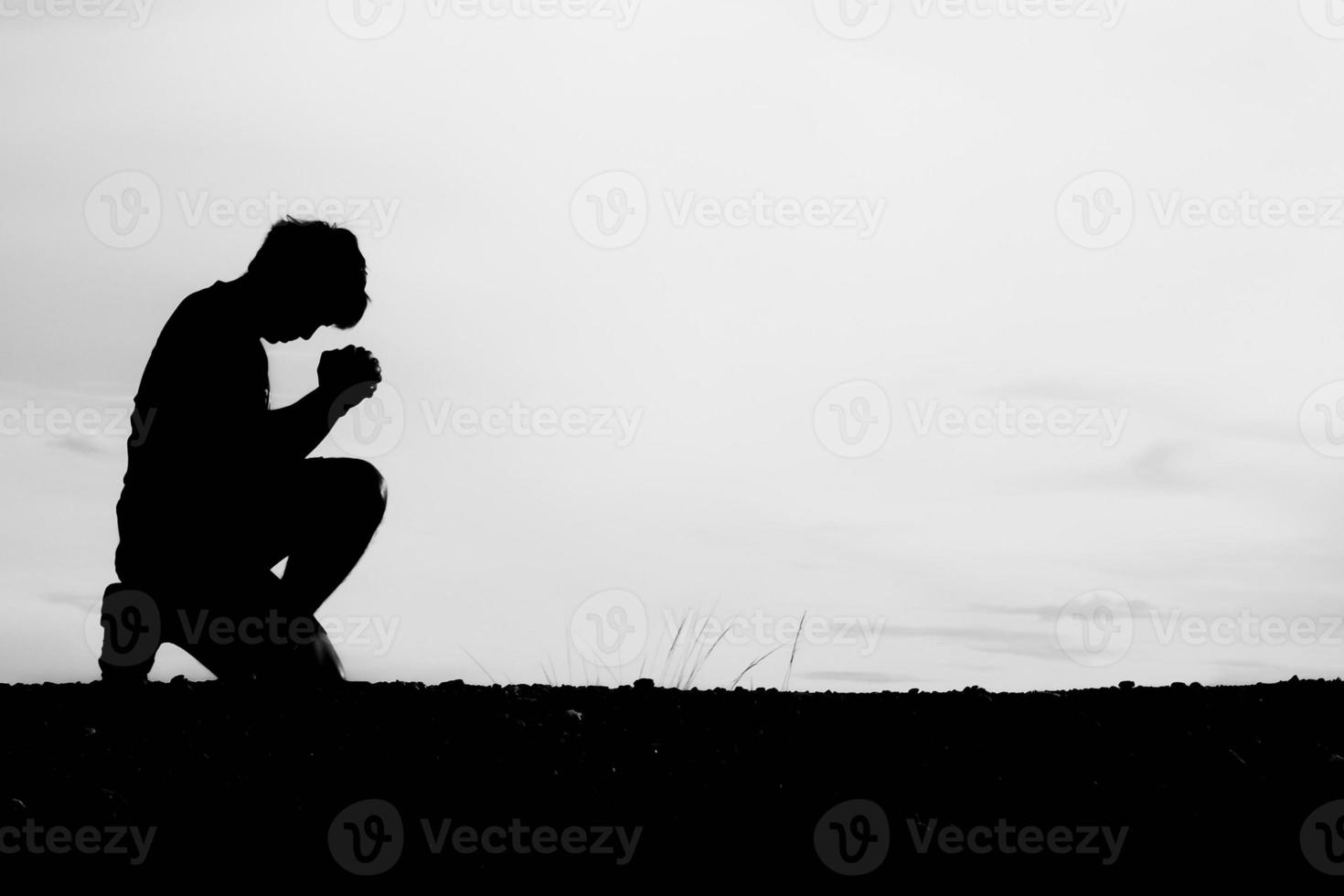 sagome di uomini seduti e che pregano per le benedizioni. concetto di speranza foto
