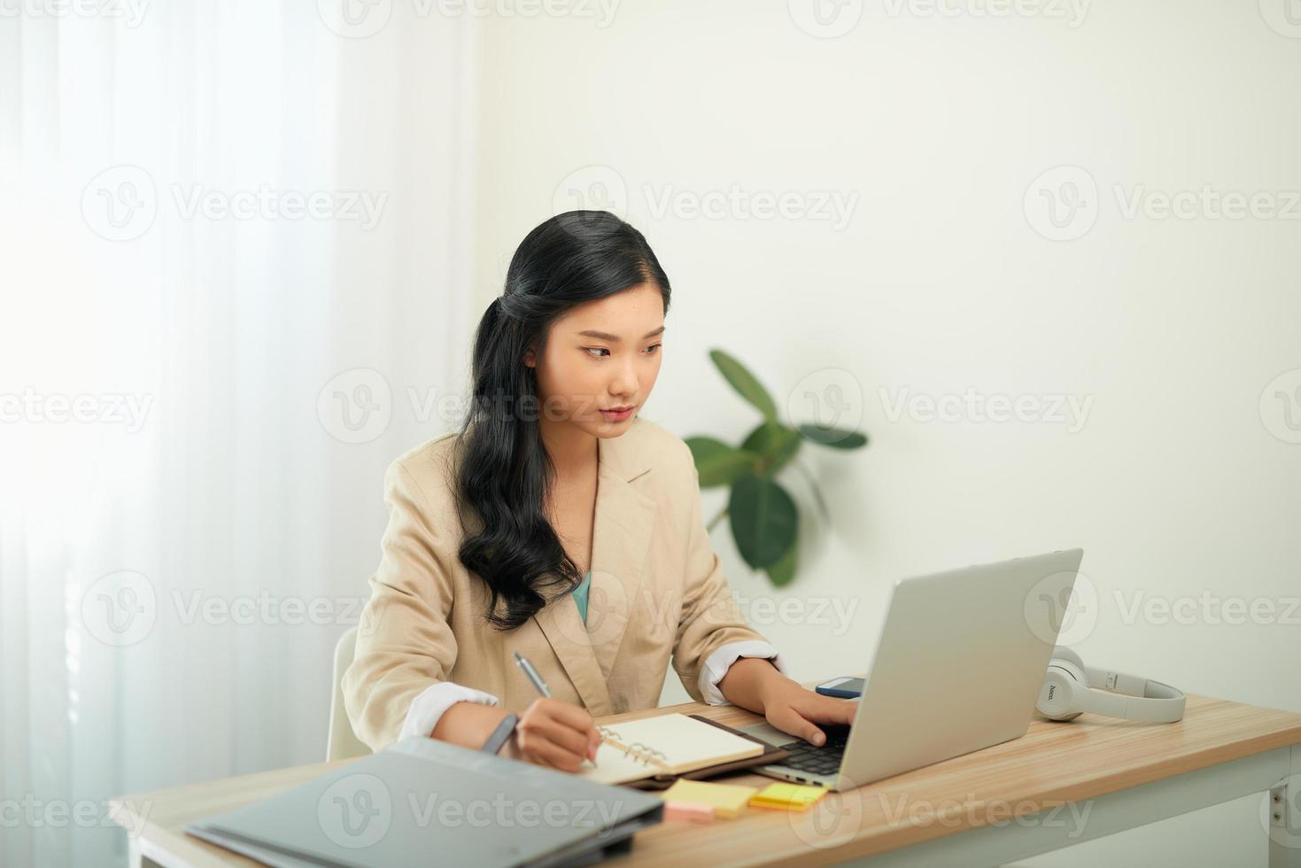 bellissimo giovane donna nel casuale capi di abbigliamento utilizzando il computer portatile e sorridente mentre Lavorando in casa foto