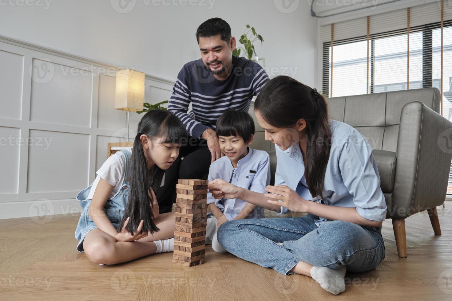 felice attività familiare tailandese asiatica adorabile, genitori, papà, mamma e bambini si divertono a giocare e gioiosi blocchi giocattolo in legno insieme sul pavimento del soggiorno, fine settimana per il tempo libero e stile di vita di benessere domestico. foto