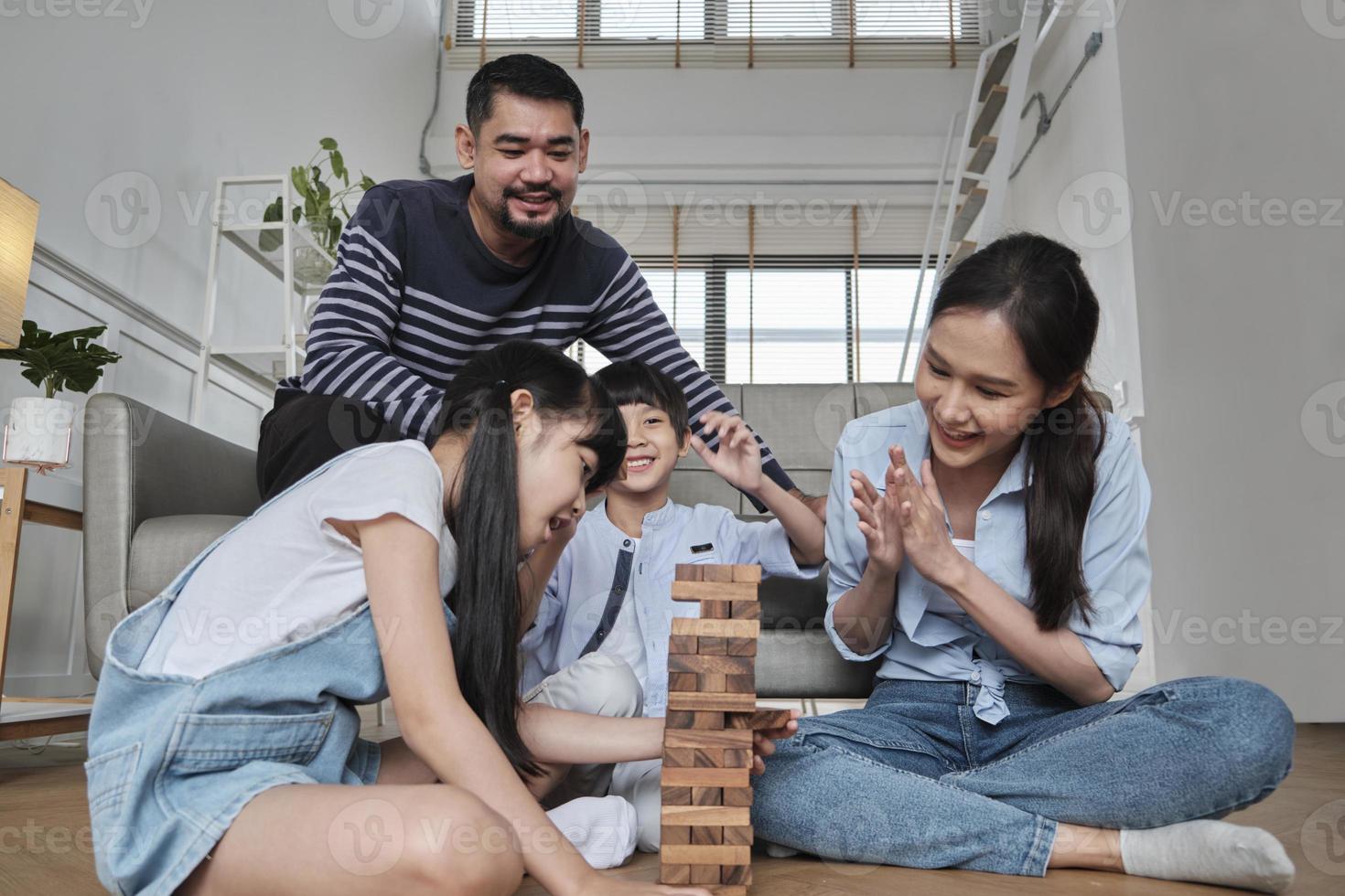 felice attività familiare tailandese asiatica adorabile, genitori, papà, mamma e bambini si divertono a giocare e gioiosi blocchi giocattolo in legno insieme sul pavimento del soggiorno, fine settimana per il tempo libero e stile di vita di benessere domestico. foto