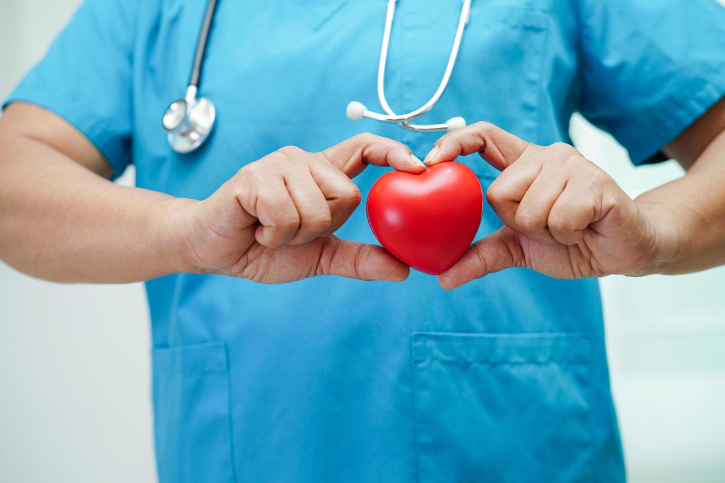 medico donna asiatica che tiene cuore rosso per la salute in ospedale. foto