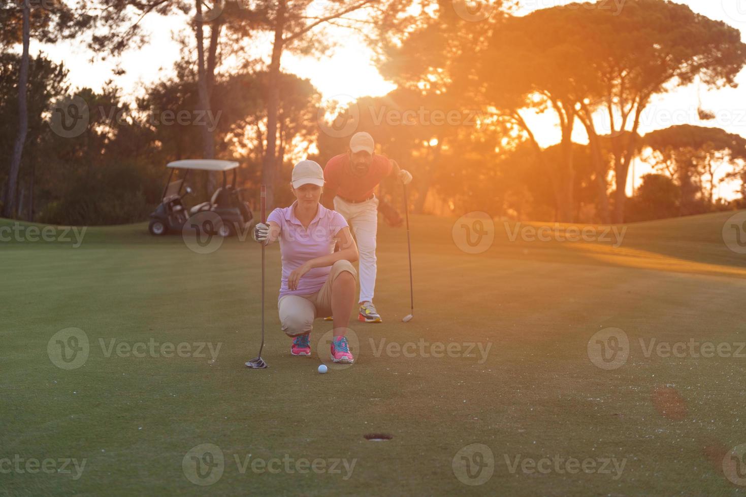 coppia su golf corso a tramonto foto