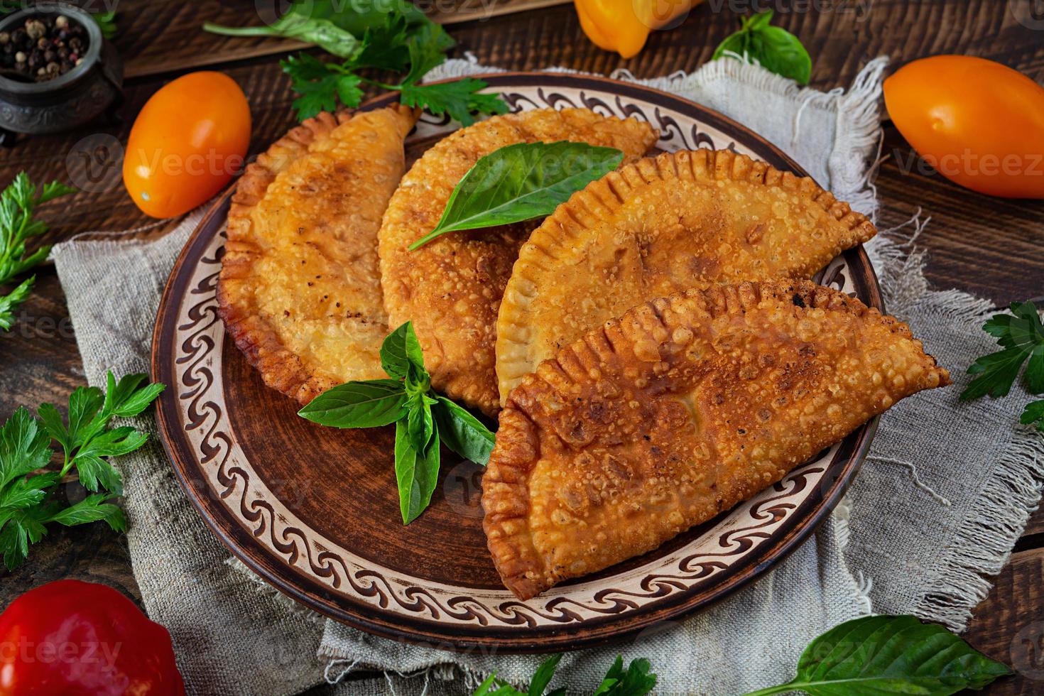 tradizionale della Crimea tatar cucina, chebureki con pollo carne. fritte empanadas su di legno sfondo foto
