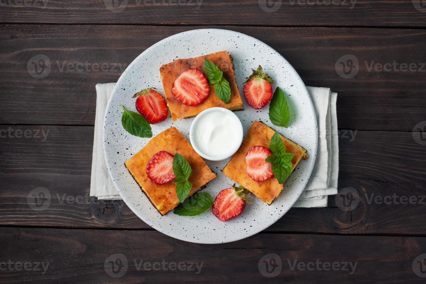 Villetta formaggio casseruola con fragole e menta. delizioso fatti in casa dolce fatto di cagliata e fresco frutti di bosco con crema. buio di legno sfondo, copia spazio. foto