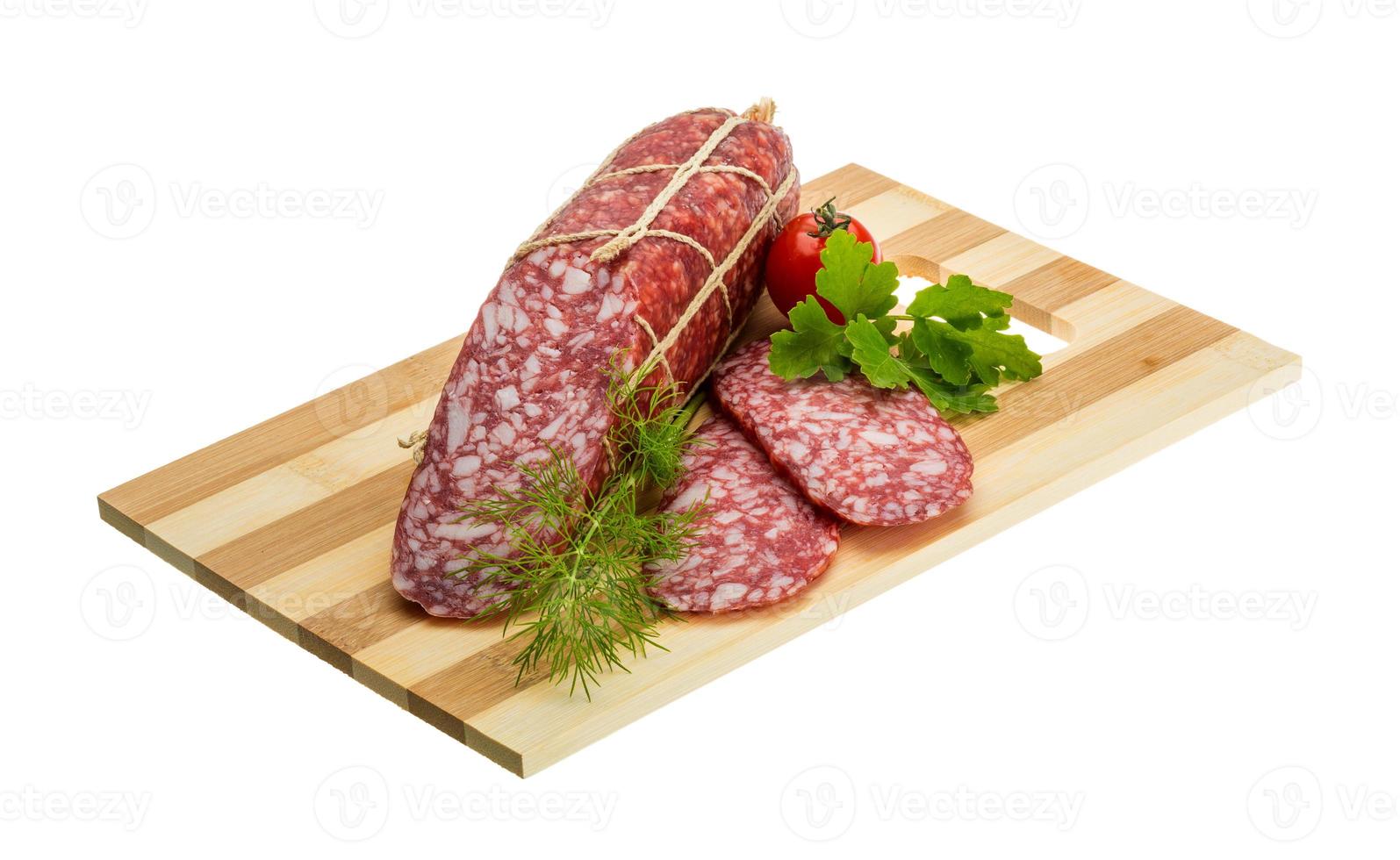 salame su di legno piatto e bianca sfondo foto