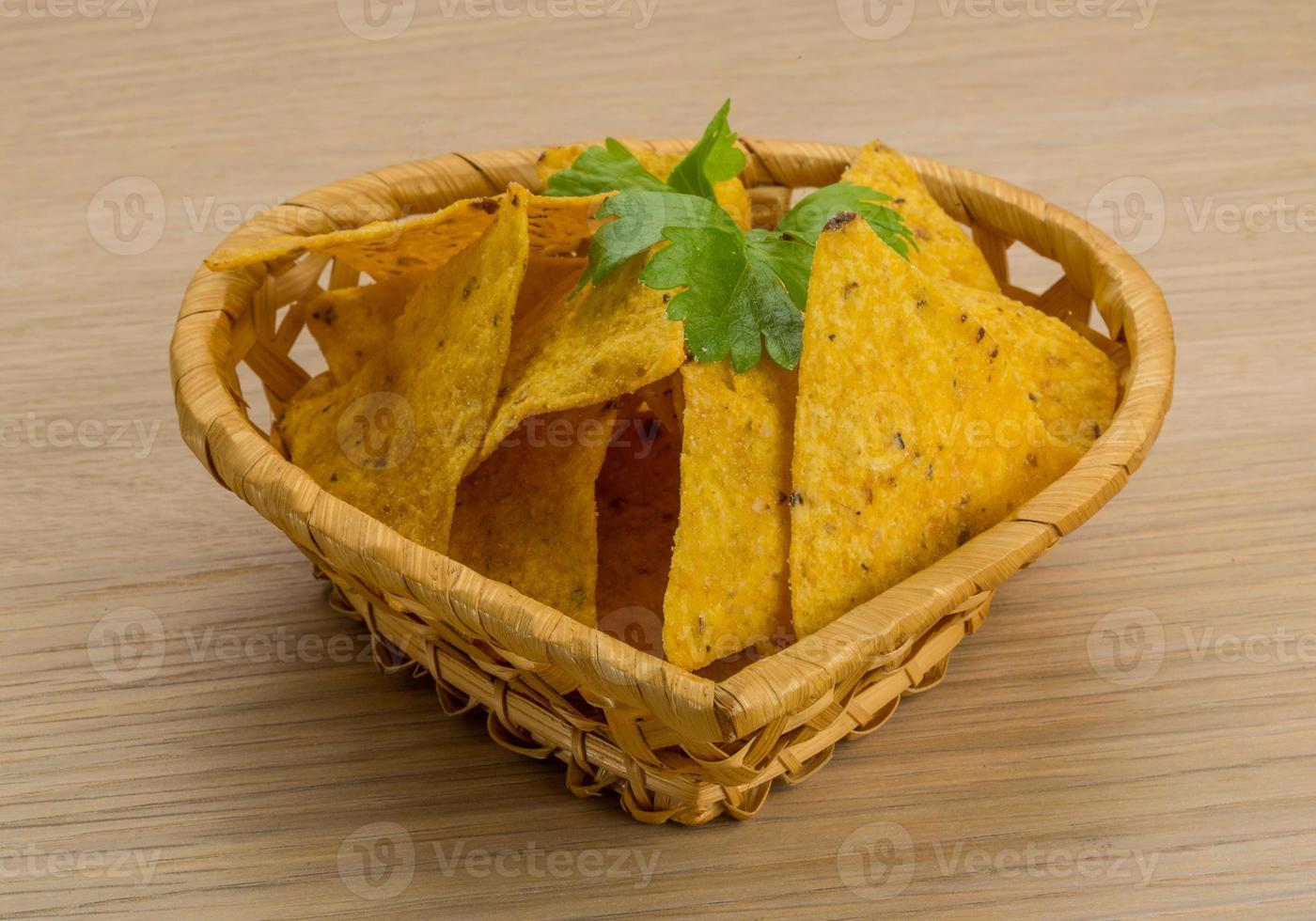 nachos in un cestino su fondo di legno foto