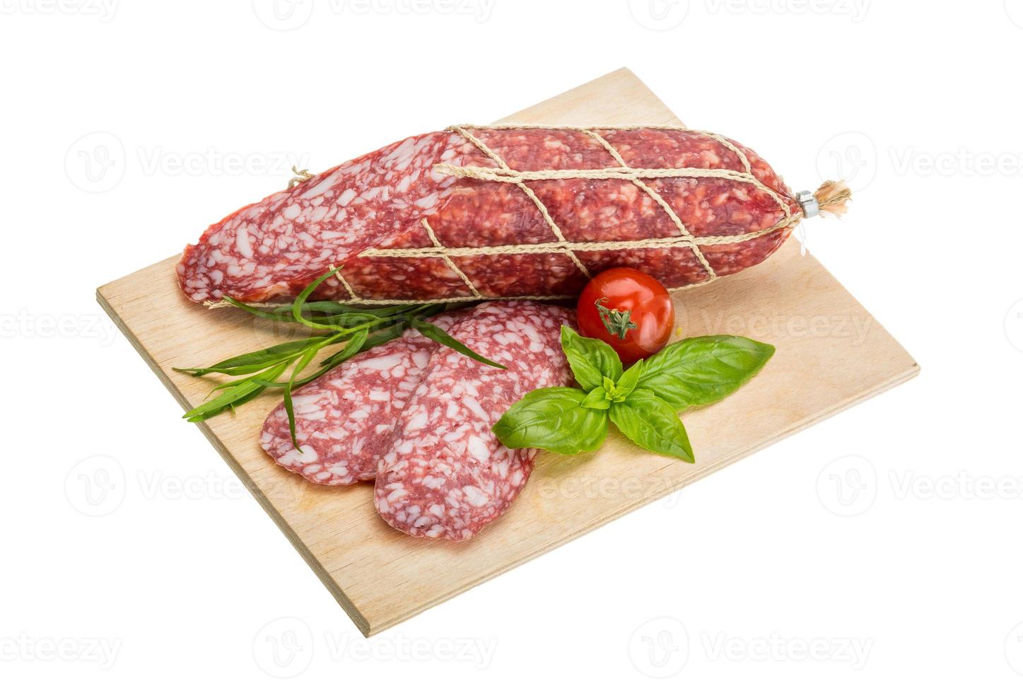 salame su di legno piatto e bianca sfondo foto