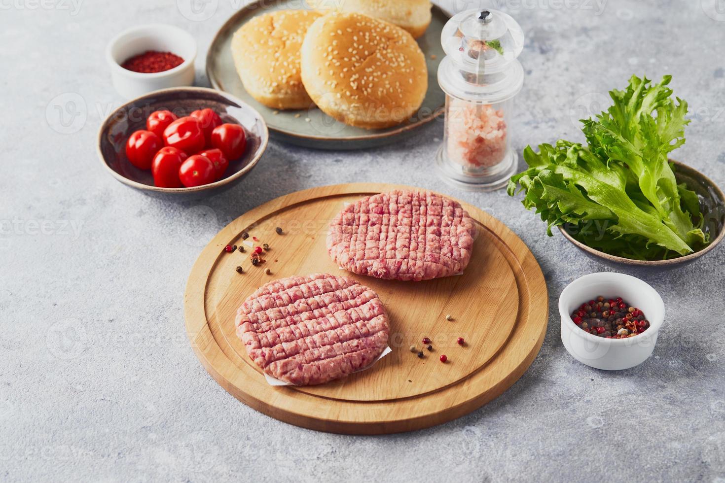 crudo vitello tritare hamburger bistecca cotolette su di legno taglio tavola foto