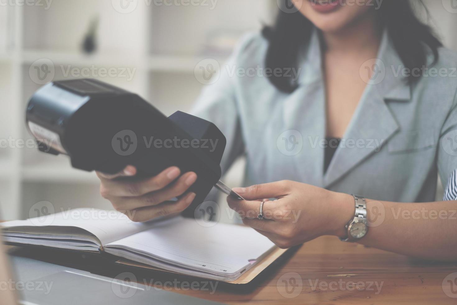 mano di donna fare pagamento con credito carta lettore macchina. foto