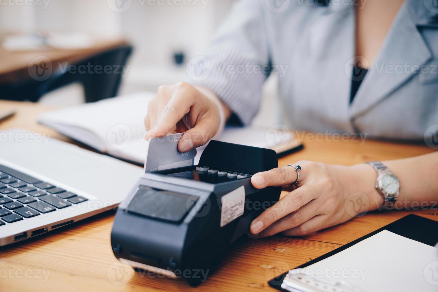 mano di donna fare pagamento con credito carta lettore macchina. foto