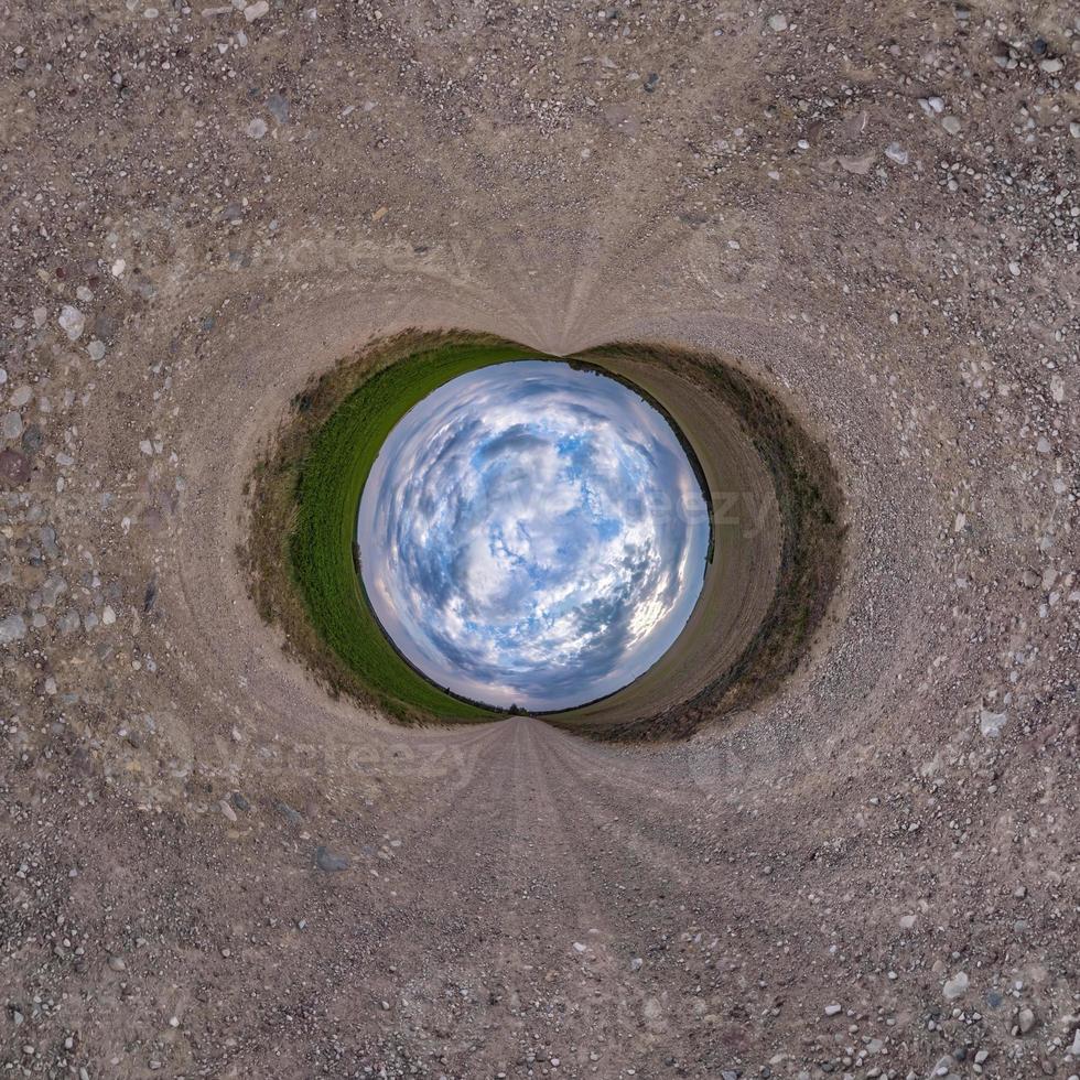 inversione del piccolo pianeta blu trasformazione del panorama sferico a 360 gradi. vista aerea astratta sferica su strada con bellissime nuvole fantastiche. curvatura dello spazio. foto