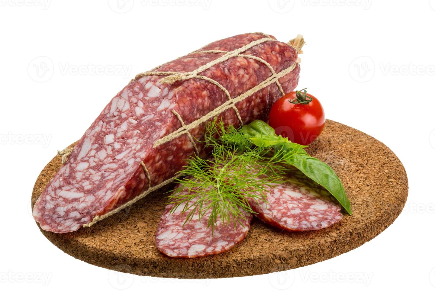 salame su di legno piatto e bianca sfondo foto