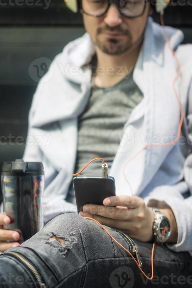 vicino su di uomo ricerca per preferito musica su inteligente Telefono. foto