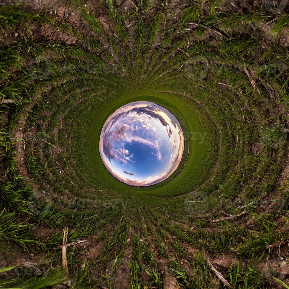 palla di cielo blu nel mezzo di una vorticosa strada asfaltata o campo. inversione del minuscolo pianeta trasformazione del panorama sferico a 360 gradi. vista astratta sferica. curvatura dello spazio. foto