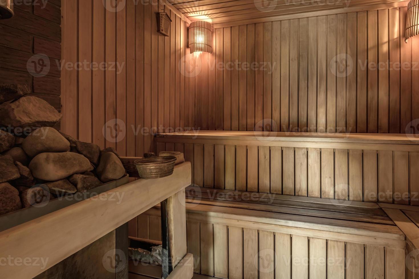 Interni di sauna da bagno russo in legno classico di design di grandi dimensioni con pietre calde foto