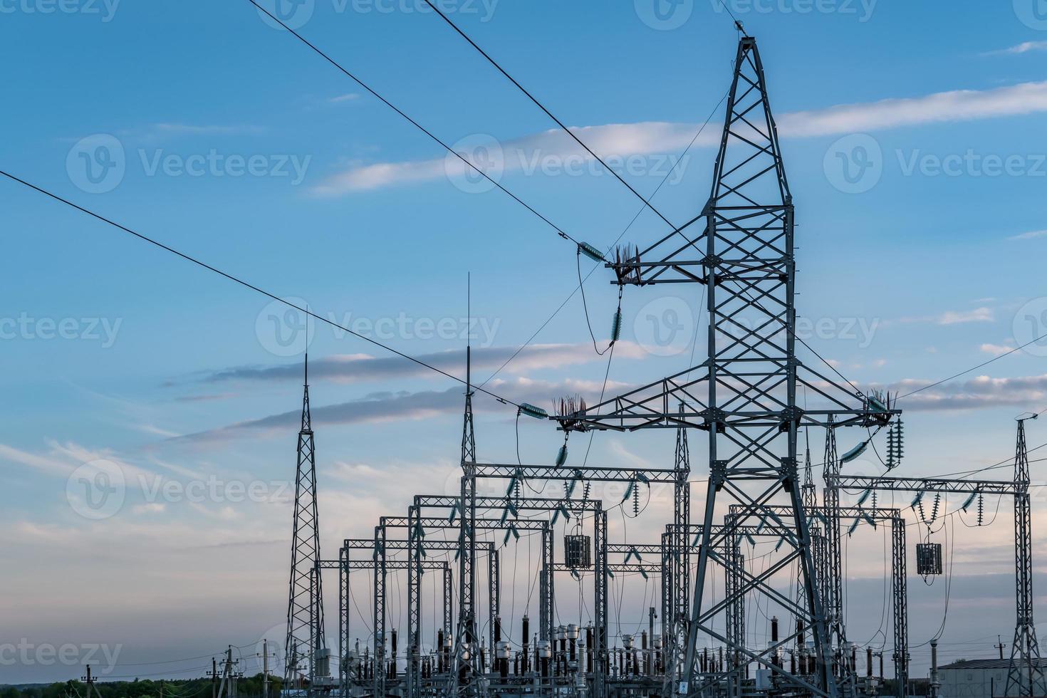 silhouette delle torri del pilone elettrico ad alta tensione sullo sfondo di belle nuvole serali foto