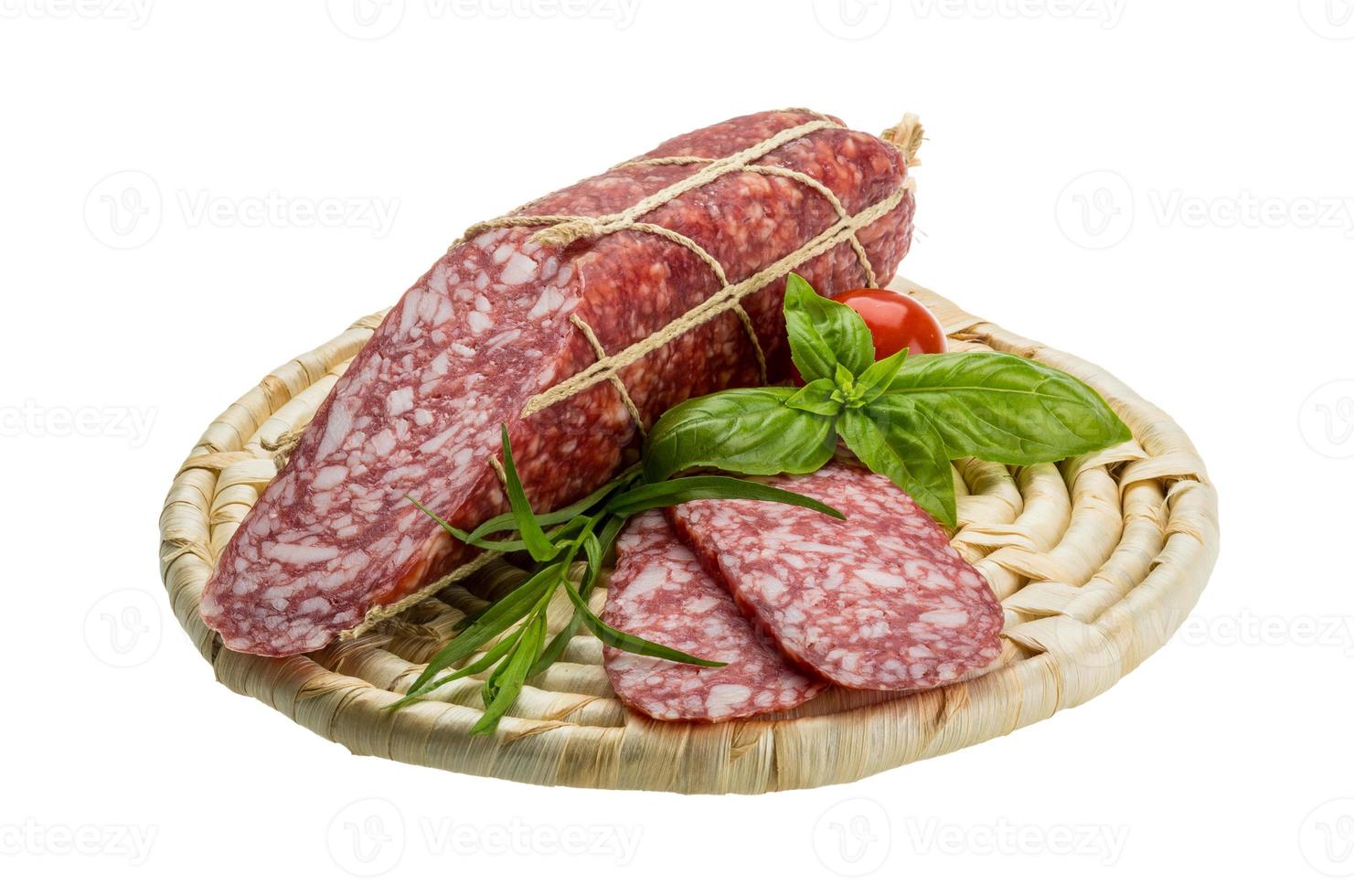 salame su di legno piatto e bianca sfondo foto