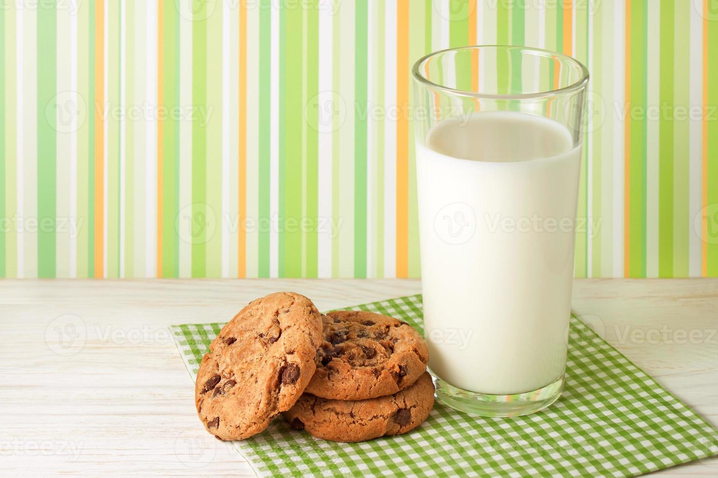 gustoso biscotti e bicchiere di latte su verde sfondo foto