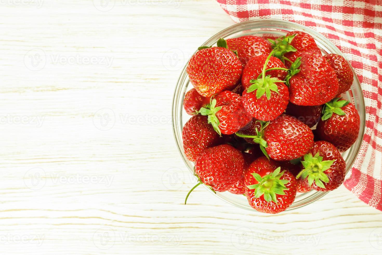 fragola nel un' ciotola su bianca di legno sfondo. superiore Visualizza, piatto posizione, copia spazio per testo foto