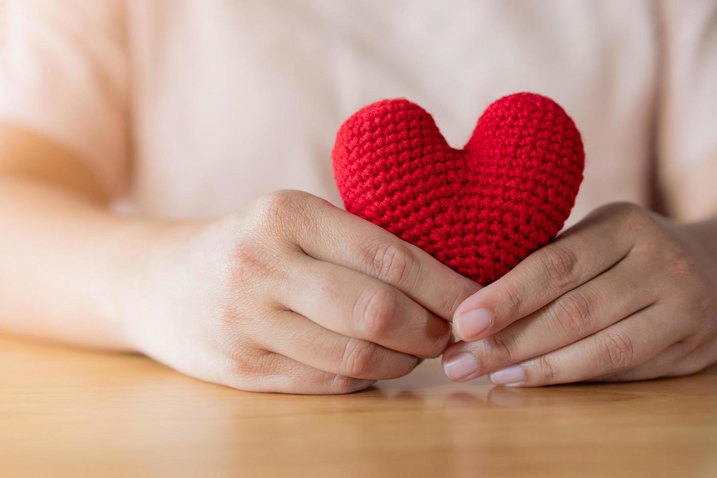 adulto mani Tenere un' filato rosso cuore foto