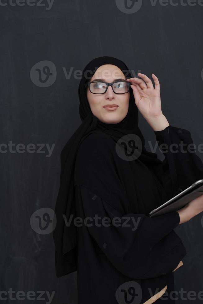 giovane arabo donna d'affari nel tradizionale Abiti o abaya Tenere tavoletta computer foto