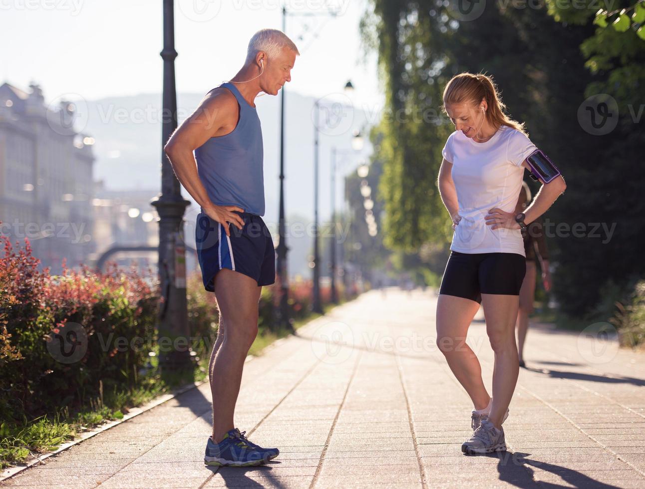 coppia che fa jogging che pianifica il percorso di corsa e imposta la musica foto