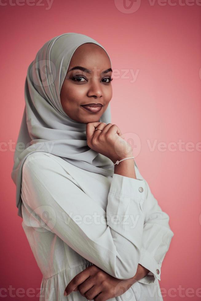 ritratto di giovane moderno musulmano afro bellezza indossare tradizionale islamico Abiti su plastica rosa sfondo. selettivo messa a fuoco foto