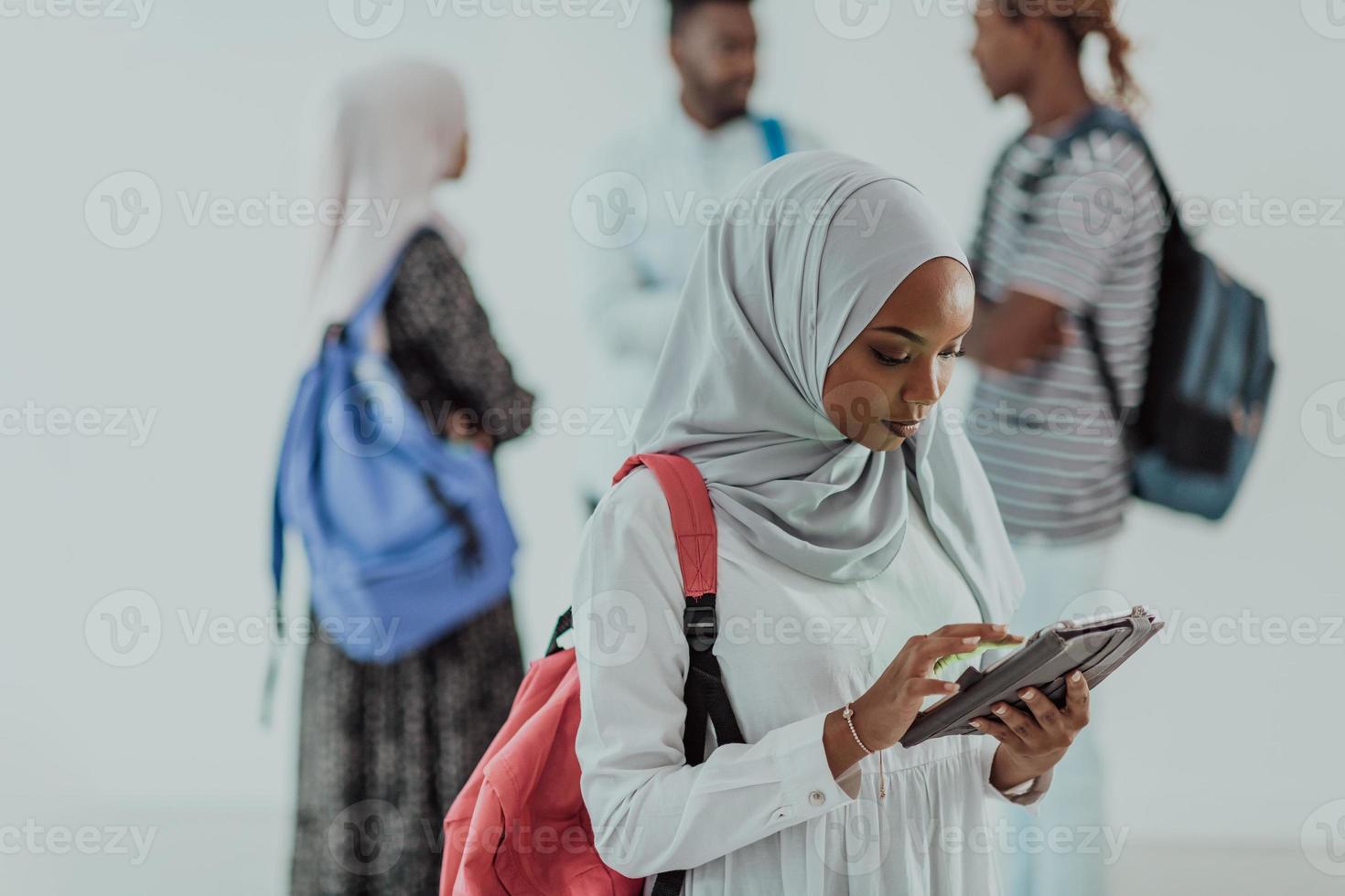 africano femmina alunno con gruppo di amici nel sfondo indossare tradizionale islamico hijab Abiti. selettivo messa a fuoco foto