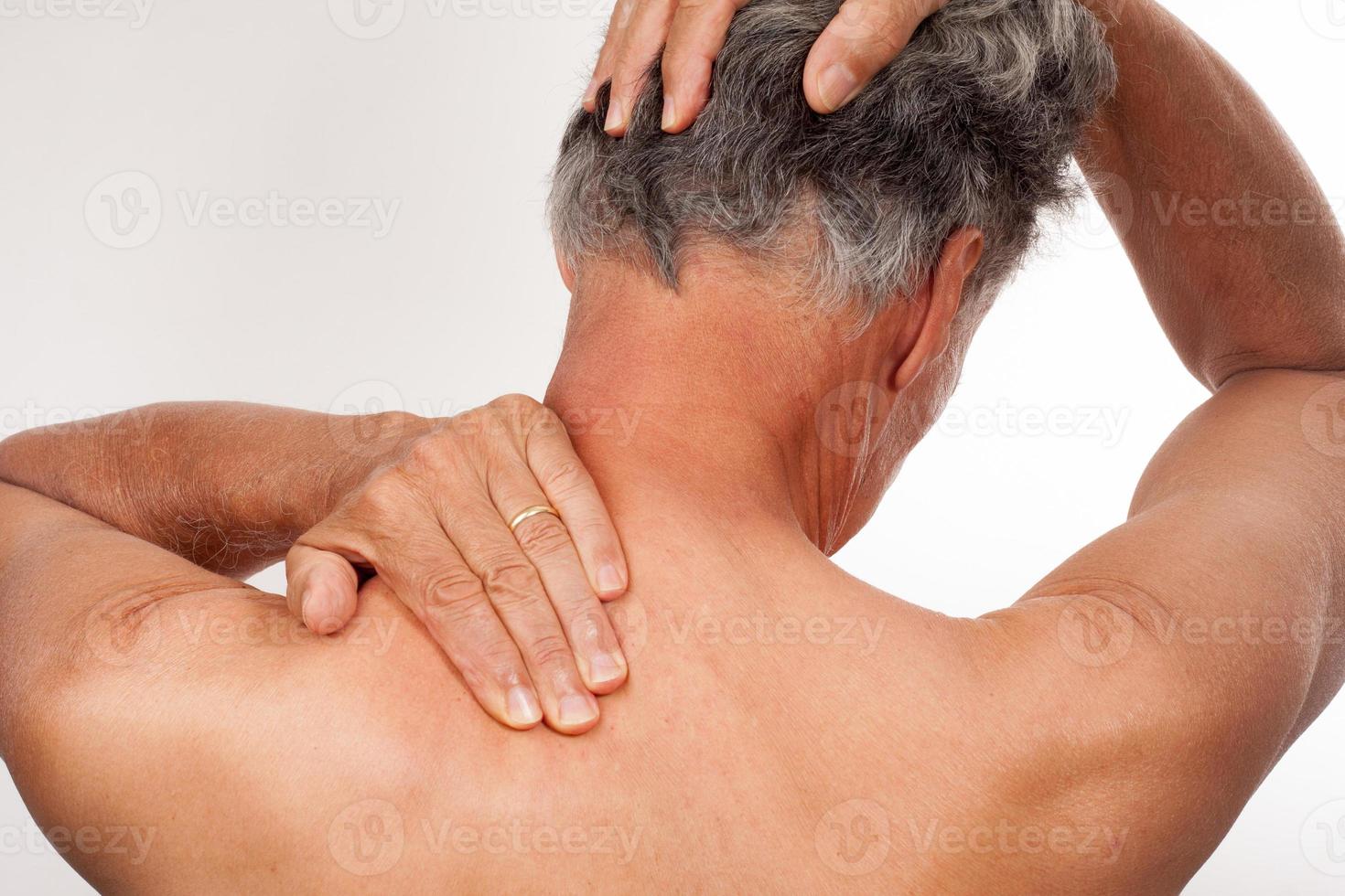 maturo uomo 60+ fare indietro di il collo tratti per indietro e collo dolore sollievo foto