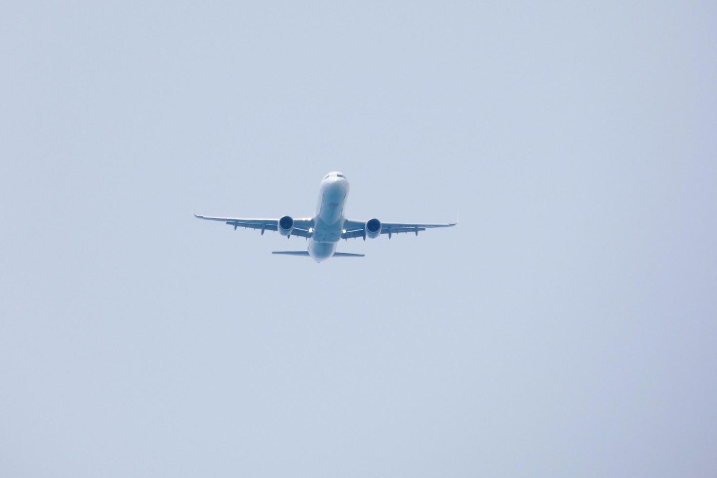 commerciale aereo volante sotto blu cieli e in arrivo a il aeroporto foto