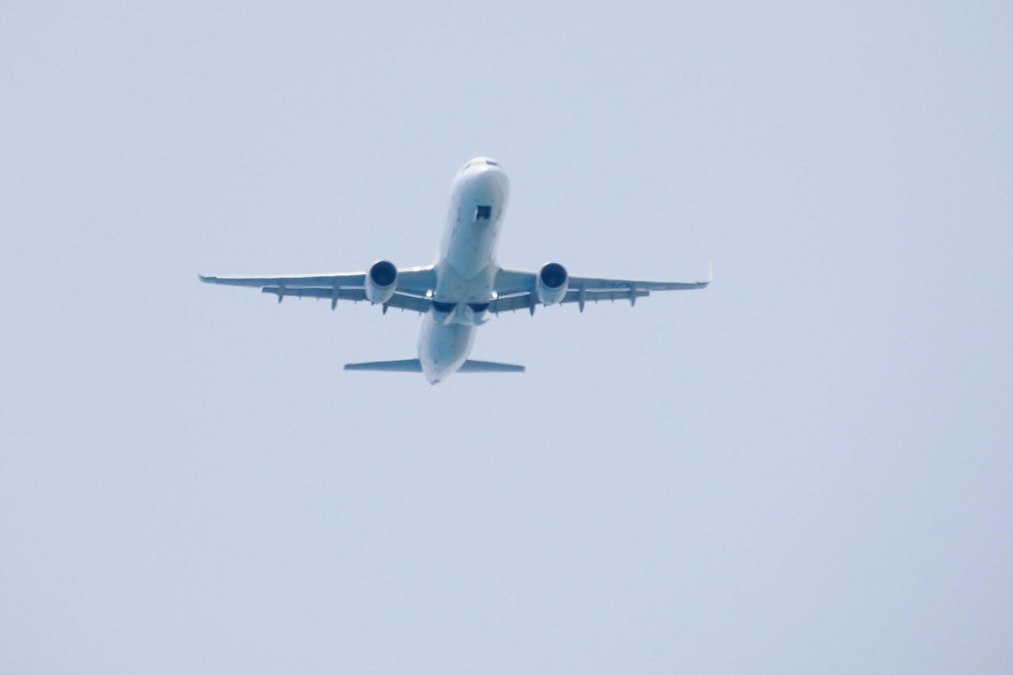 commerciale aereo volante sotto blu cieli e in arrivo a il aeroporto foto