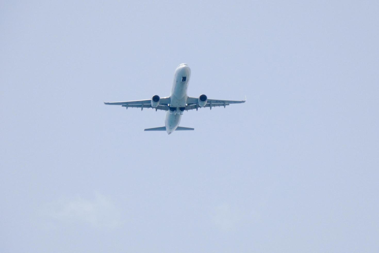 commerciale aereo volante sotto blu cieli e in arrivo a il aeroporto foto