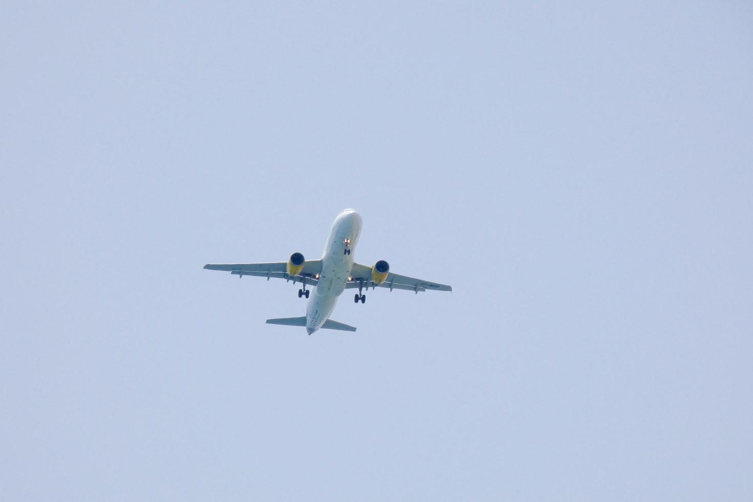 commerciale aereo volante sotto blu cieli e in arrivo a il aeroporto foto