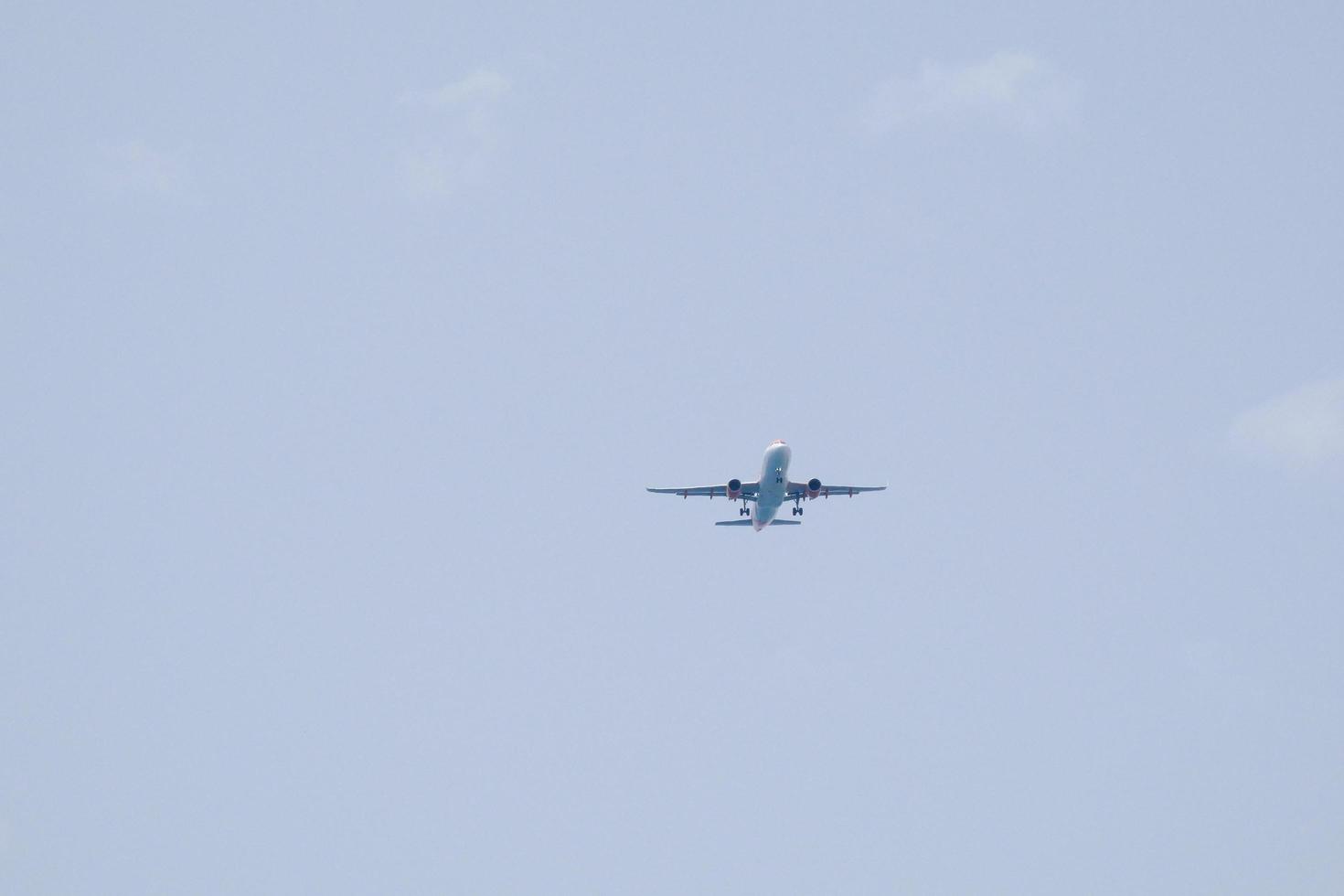 commerciale aereo volante sotto blu cieli e in arrivo a il aeroporto foto