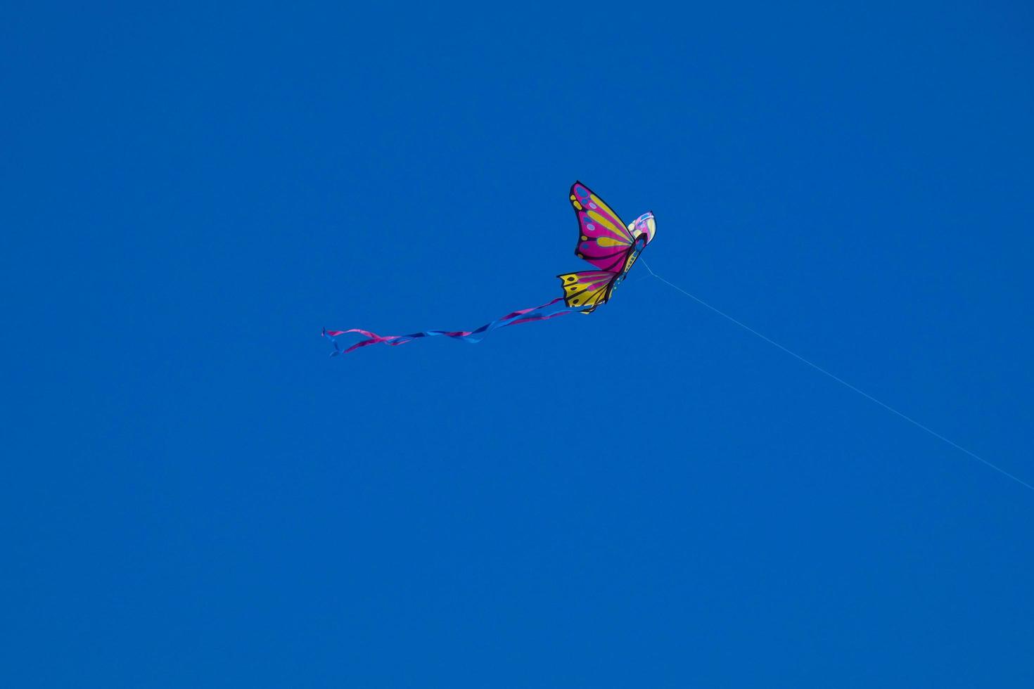 colorato aquilone volante sotto il blu cielo foto