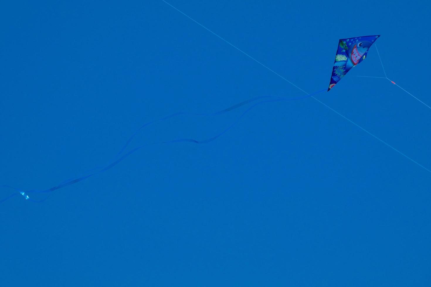 colorato aquilone volante sotto il blu cielo foto