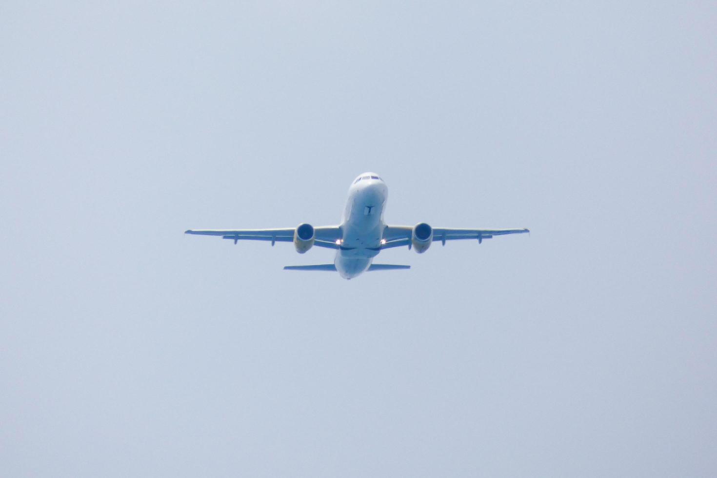 commerciale aereo volante sotto blu cieli e in arrivo a il aeroporto foto