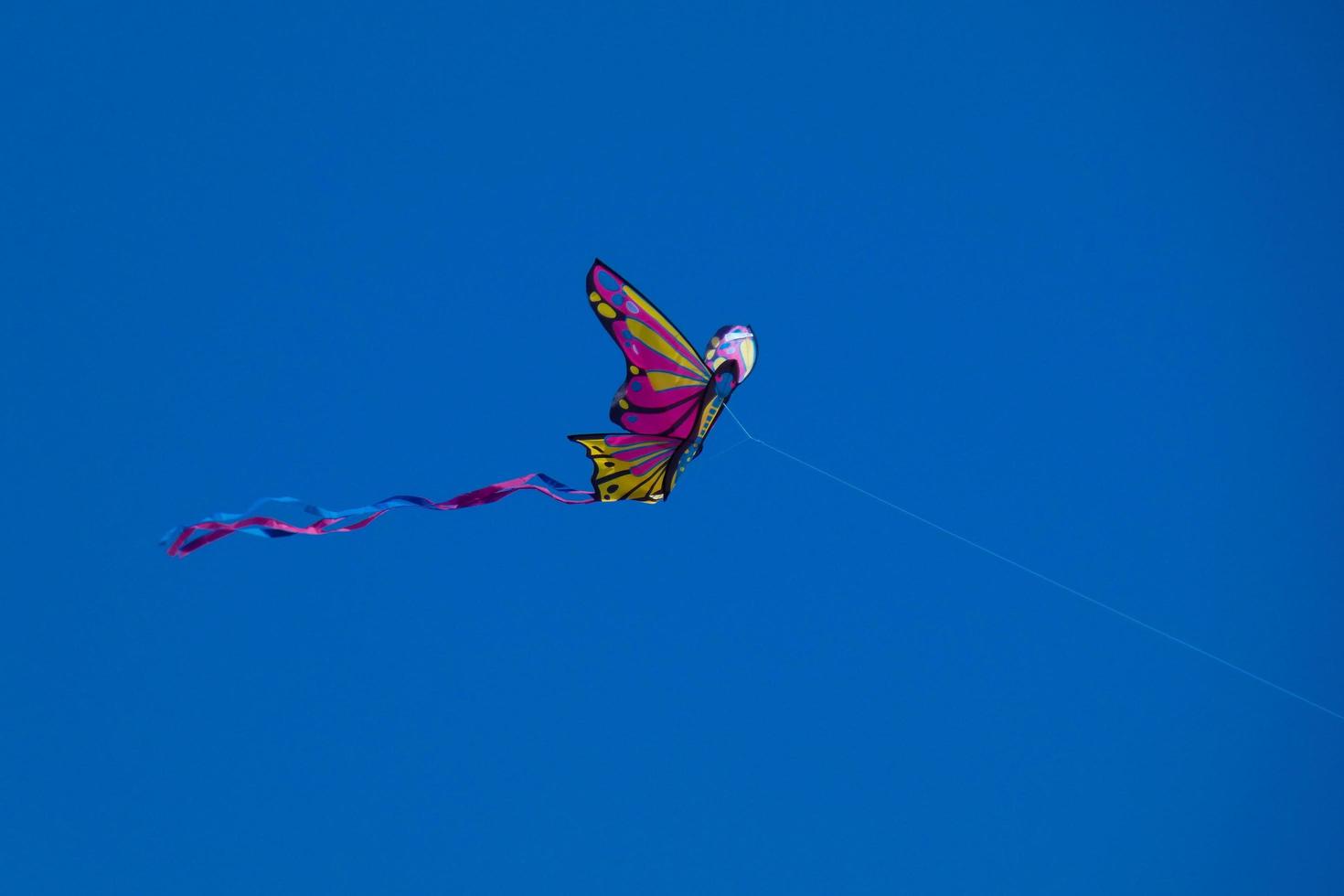 colorato aquilone volante sotto il blu cielo foto