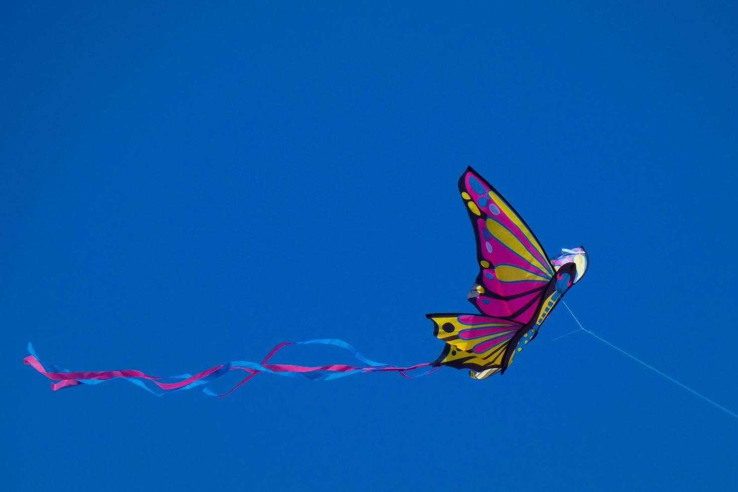 colorato aquilone volante sotto il blu cielo foto