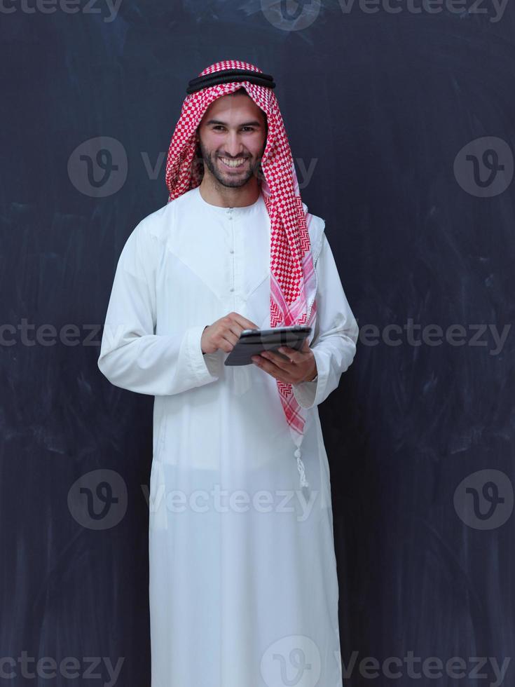 giovane arabo musulmano uomo d'affari utilizzando tavoletta computer foto