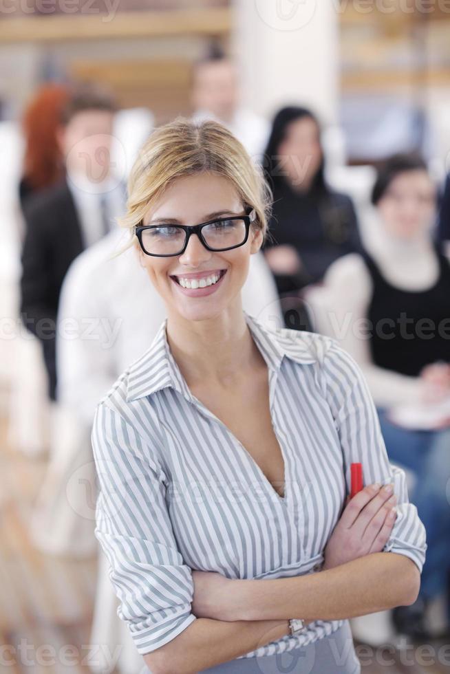 donna d'affari in piedi con il suo staff alla conferenza foto