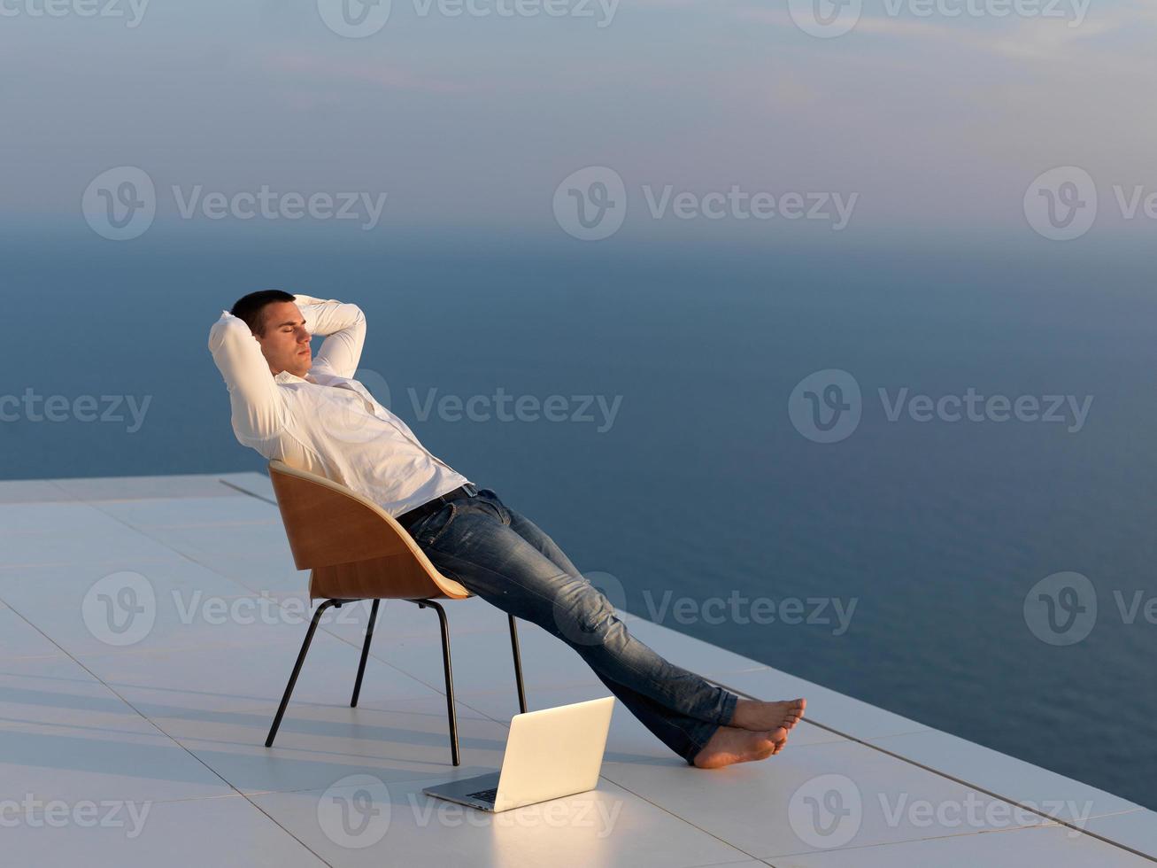 rilassato giovane uomo a casa su balcone foto