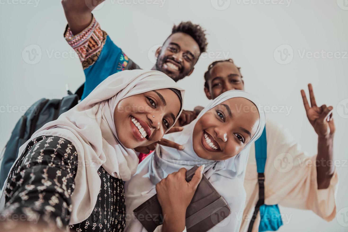un' gruppo di multietnico studenti prendere un' autoscatto con un' smartphone su un' bianca sfondo. selettivo messa a fuoco foto