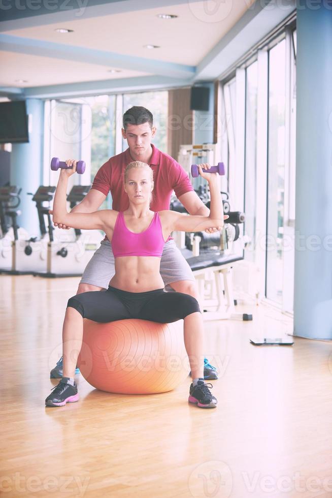 giovane sportivo donna con allenatore esercizio pesi sollevamento foto