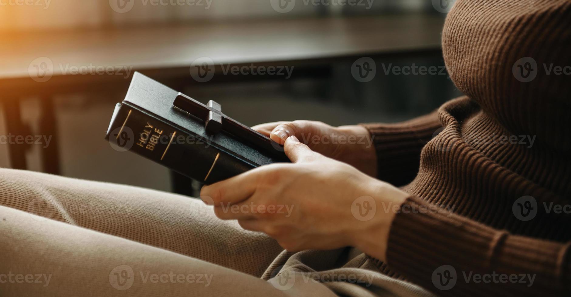 un' donna preghiere Tenere un' santo Bibbia e pregare per Dio. foto