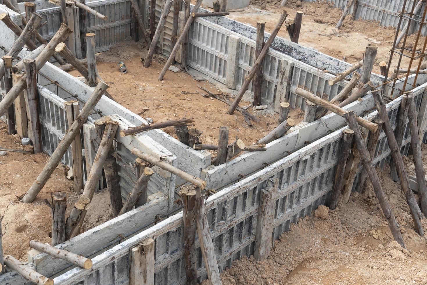 bloccare cassaforma per Casa travi con supportato di di legno registri. costruzione di il fondazione di il Casa su il terra durante il giorno volta. foto