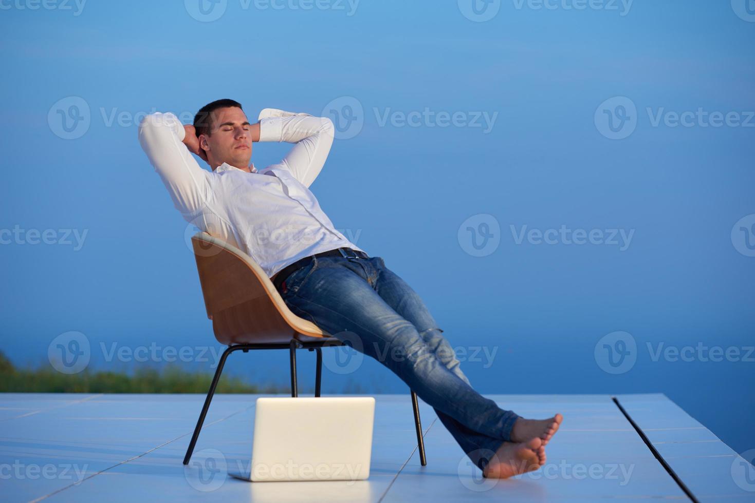 rilassato giovane uomo a casa su balcone foto